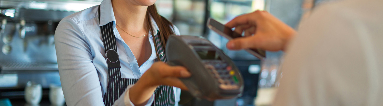 woman accepting payment at cafe