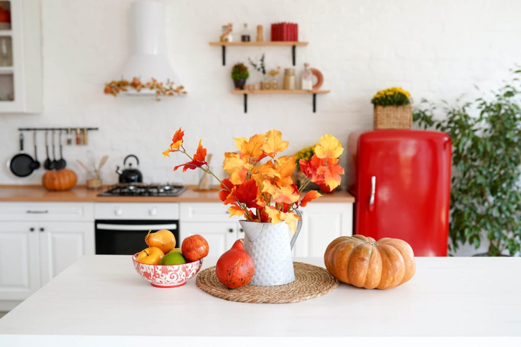 pitcher with fall flowers and pumpkins in kitchen scene