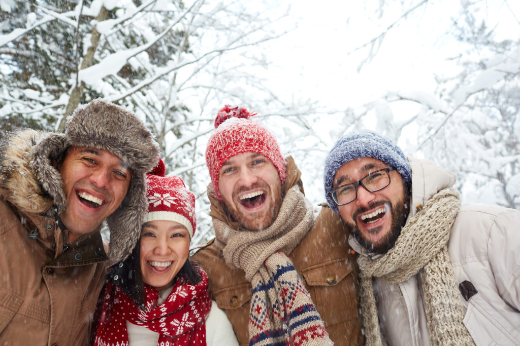 multicultural group smiling in snow