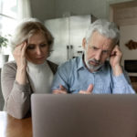 mature couple looking at computer distressed