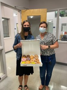 Pathways employees holding doughnuts with acclaim employee