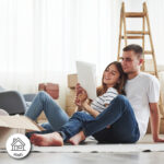 young couple on the floor looking at floor plans